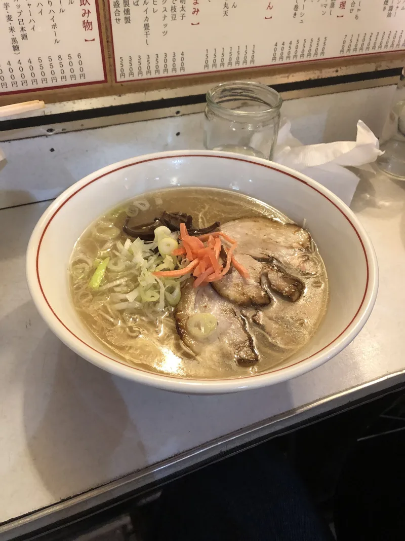 Hakata-style ramen with pork slices, red pickled ginger and green onion in a creamy pork-bone broth