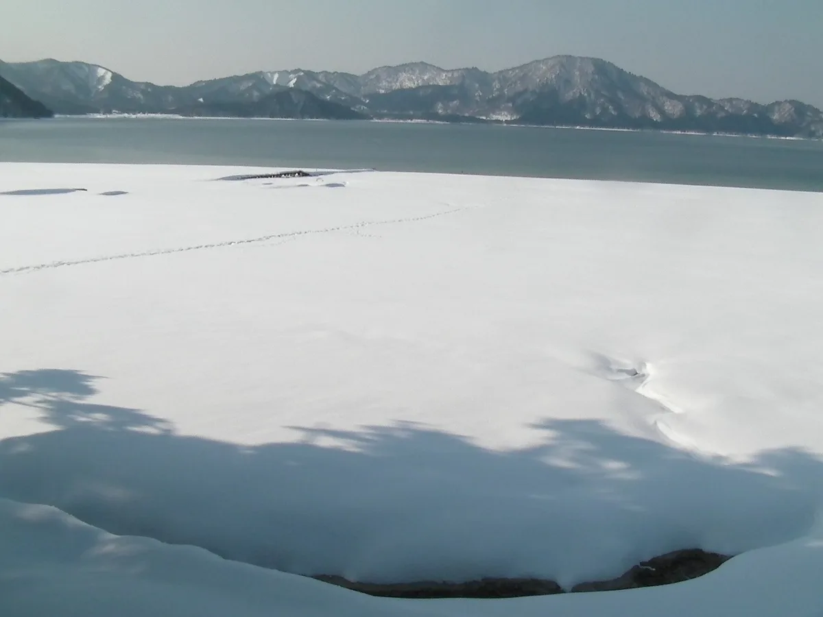 Snowy winter view across Lake Tazawa from its eastern shore