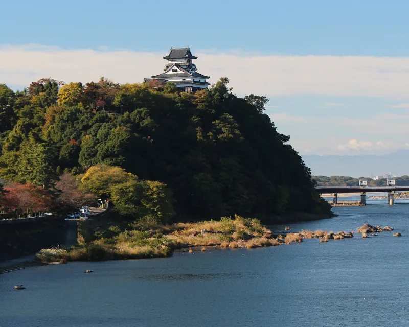 Inuyama Castle on its wooded hill above the Kiso River, seen from Inuyama Bridge