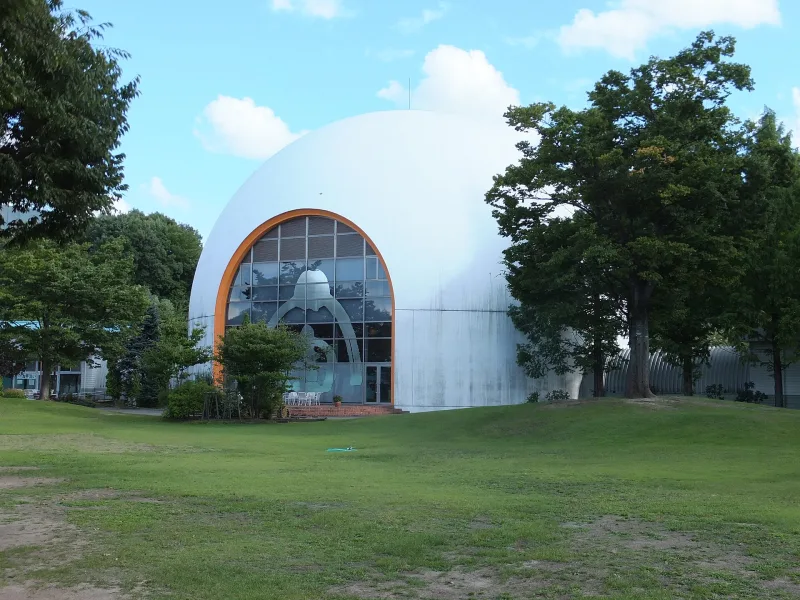 White dome-shaped planetarium building Spacia on a lawn at Akita Furusato Mura