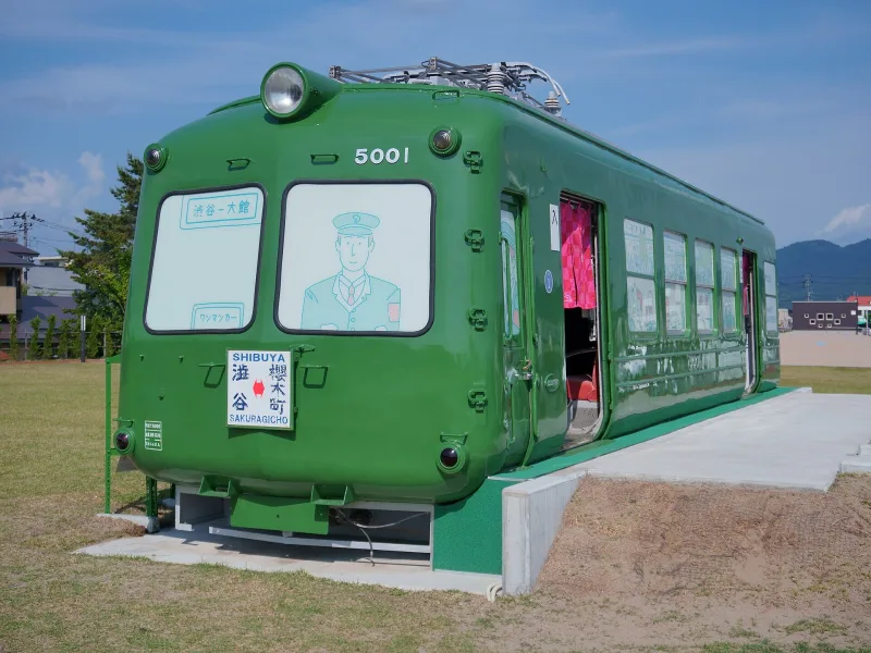 Green 'Aogaeru' Tokyu 5000 series railcar displayed on the lawn at Odate