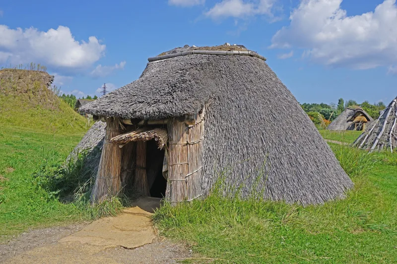 Reconstructed thatched Jomon pit dwelling on the grass at Sannai-Maruyama