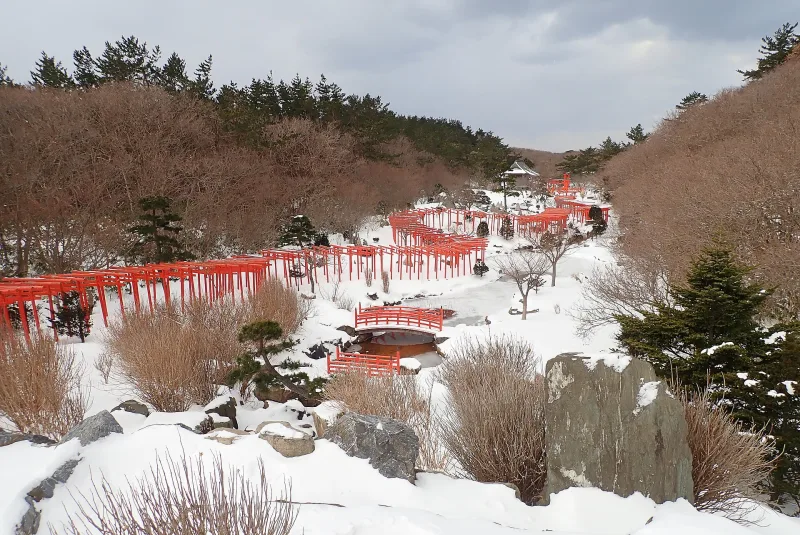 The winding torii tunnel of Takayama Inari Shrine in deep winter snow