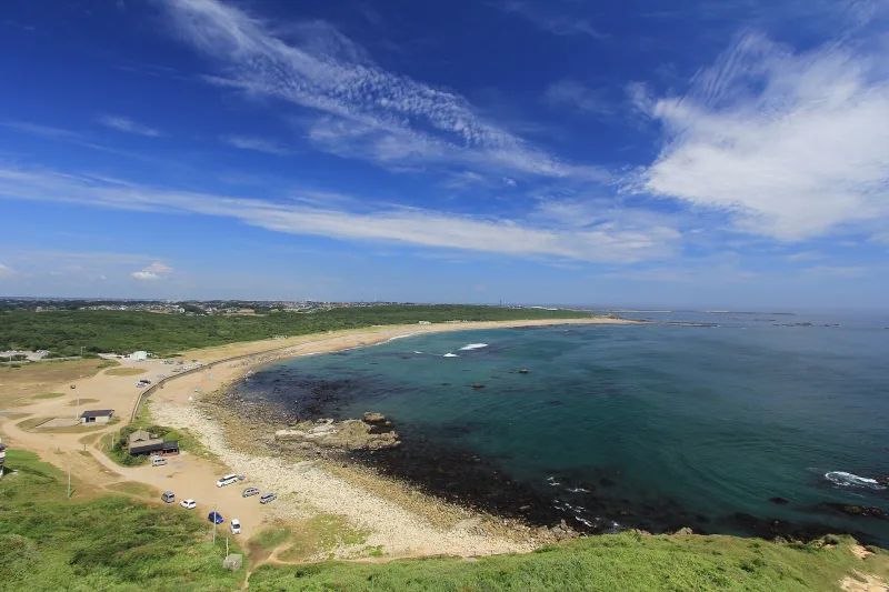 View from Inubosaki Lighthouse over a curving sandy beach and the blue Pacific Ocean
