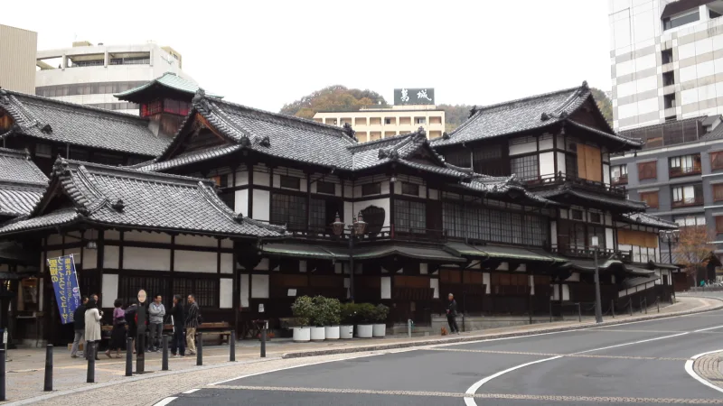 Dogo Onsen Honkan's layered tiled roofs seen from the street