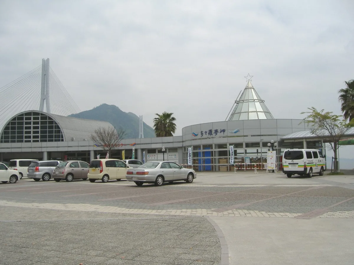 The Tatara Shimanami Park roadside station building, with the tower of Tatara Bridge behind it