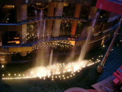 Evening fountain show with lit water jets in the canal at the center of Canal City Hakata