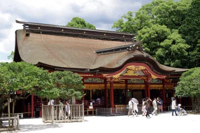 The ornate main hall of Dazaifu Tenmangu with its sweeping bark roof and red and gold front