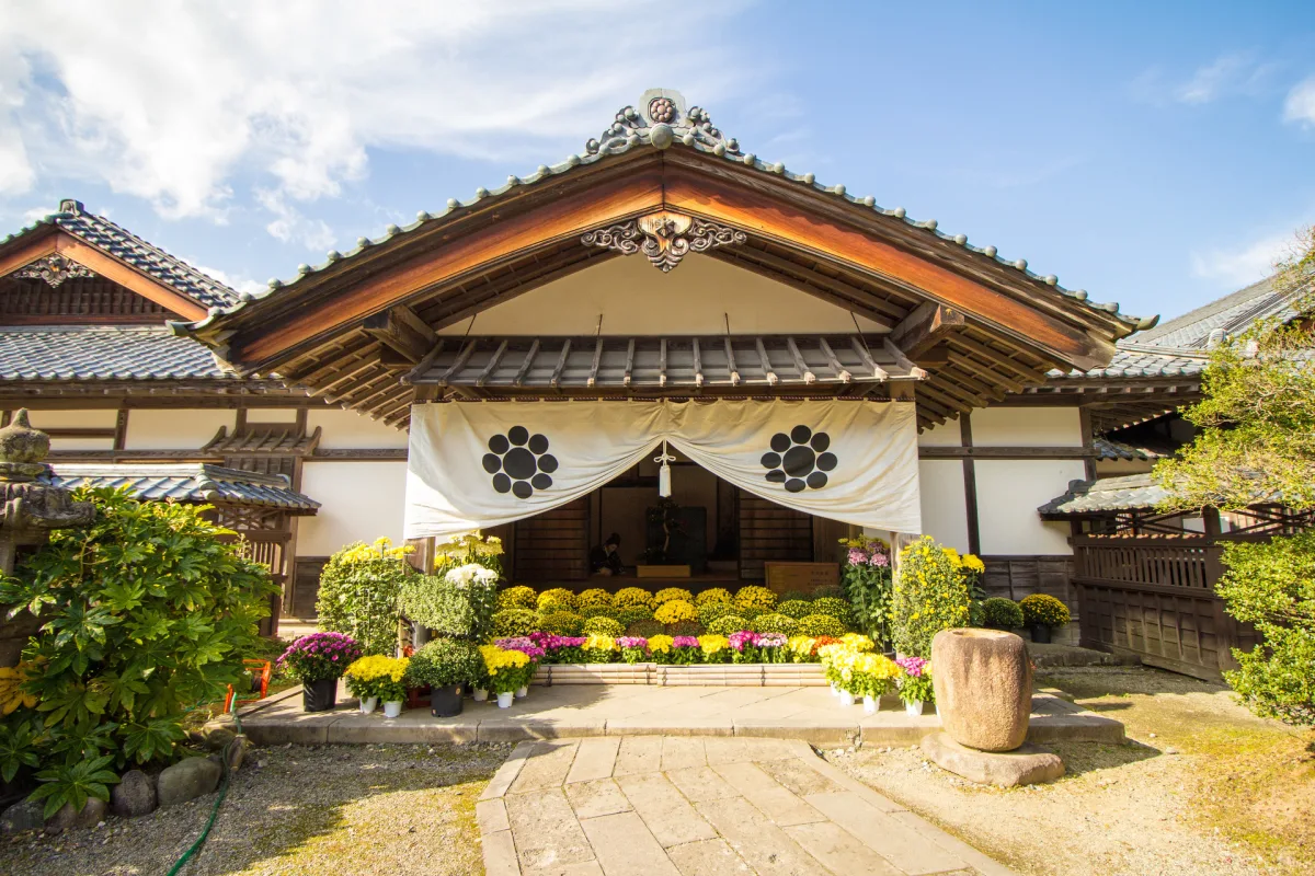 Entrance of the reconstructed chief retainer's residence at Aizu Bukeyashiki with chrysanthemums