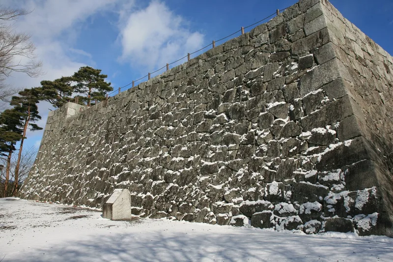 Tall stone walls of the Nihonmatsu Castle main enclosure with a dusting of snow