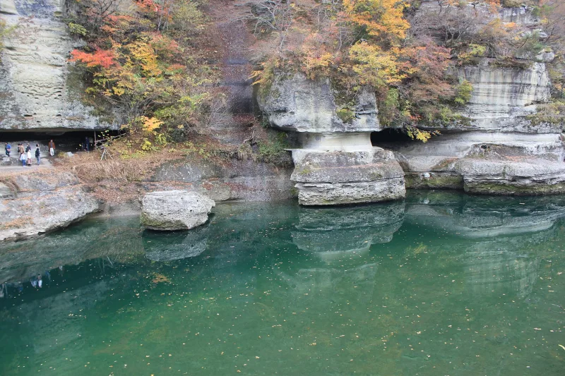Eroded rock pillars and ledges along the green river at To-no-Hetsuri in autumn