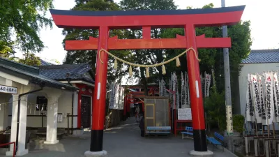 Red torii gate with a straw rope at the entrance to Chiyobo Inari Shrine