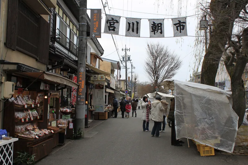 Market stalls and shops under the Miyagawa Morning Market banner in Takayama