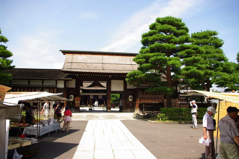 Morning market stalls in front of the Takayama Jinya gate under pine trees