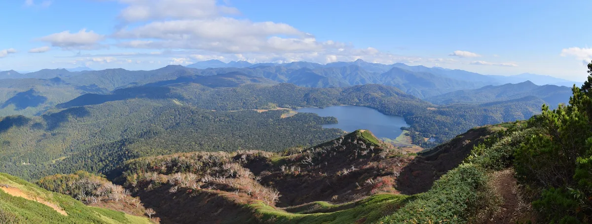 View of Lake Ozenuma from Mount Hiuchi, surrounded by mountains.