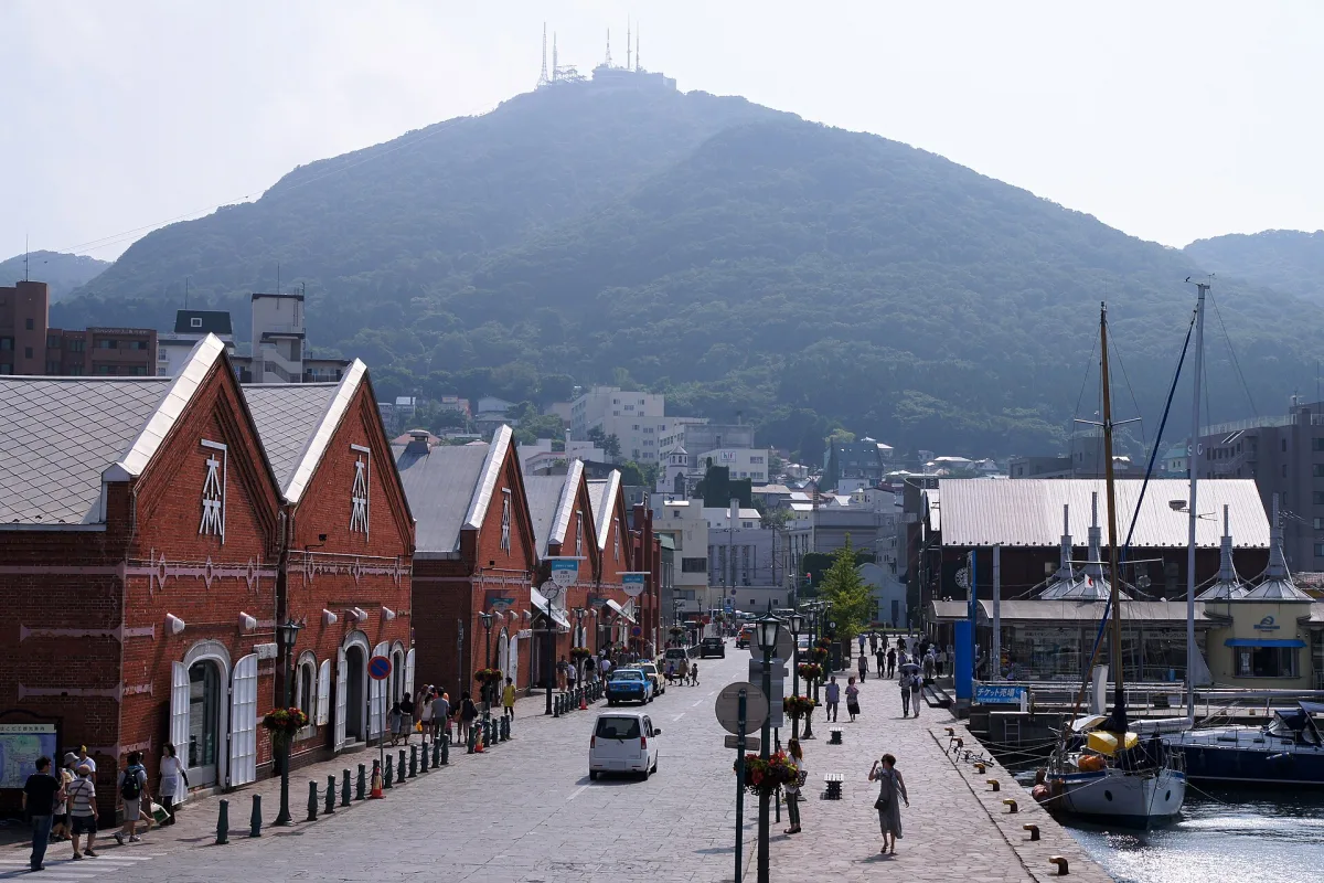Row of red brick warehouses by the harbour in Hakodate with Mount Hakodate behind