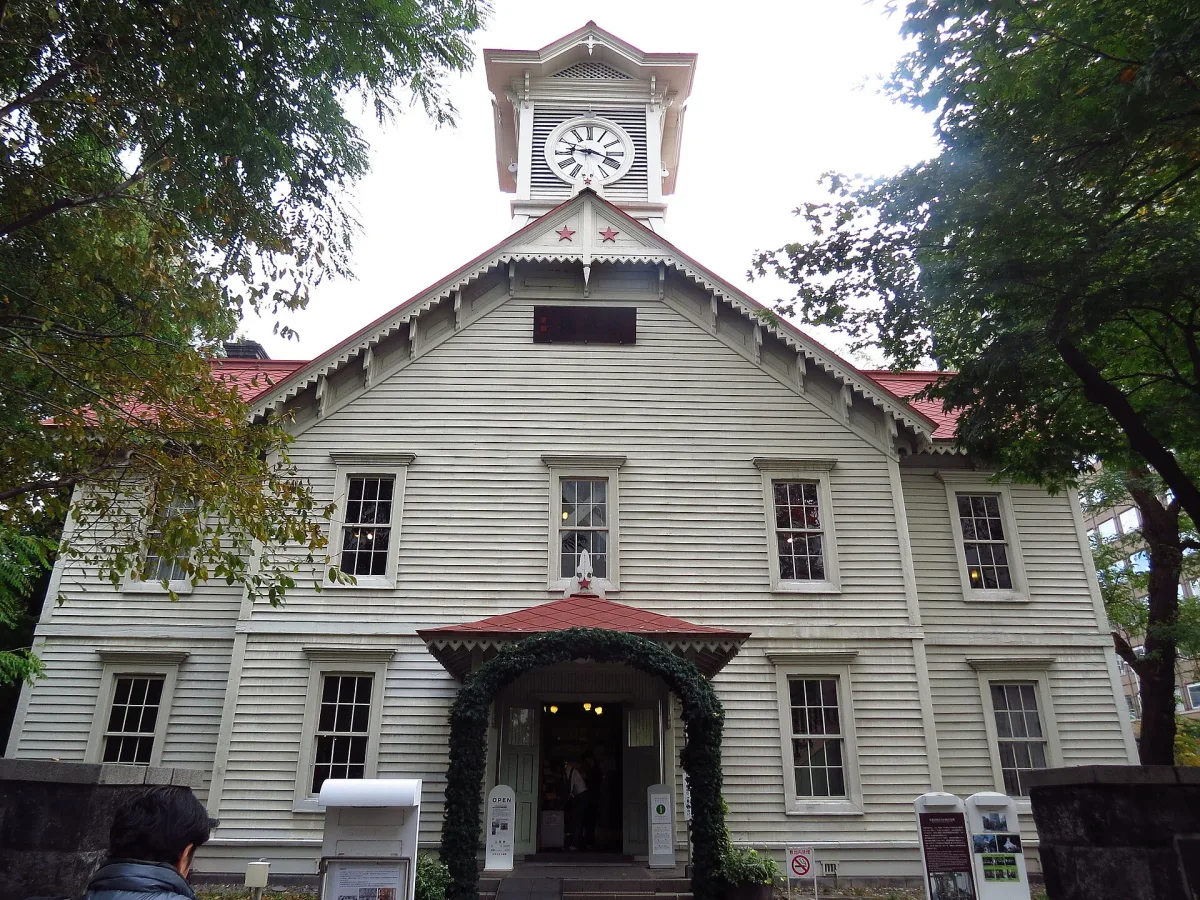 White wooden Sapporo Clock Tower with its red roof and clock face