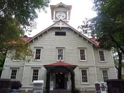 White wooden Sapporo Clock Tower with its red roof and clock face