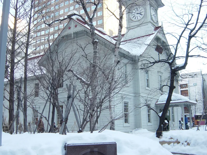 Sapporo Clock Tower among bare trees and deep snow in winter