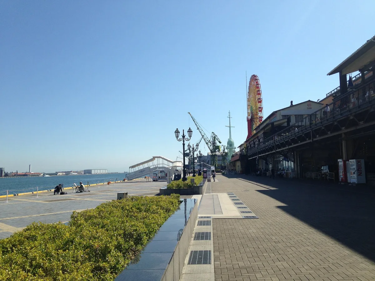 Waterfront promenade at Kobe Harborland with the Mosaic Ferris wheel and shops along the harbor