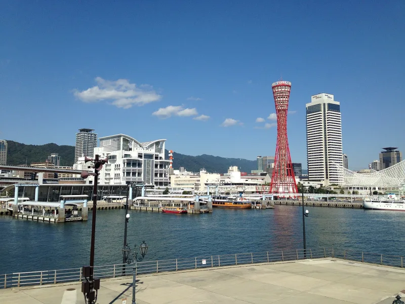 View across Kobe harbor from Harborland to the red Kobe Port Tower and Mount Rokko