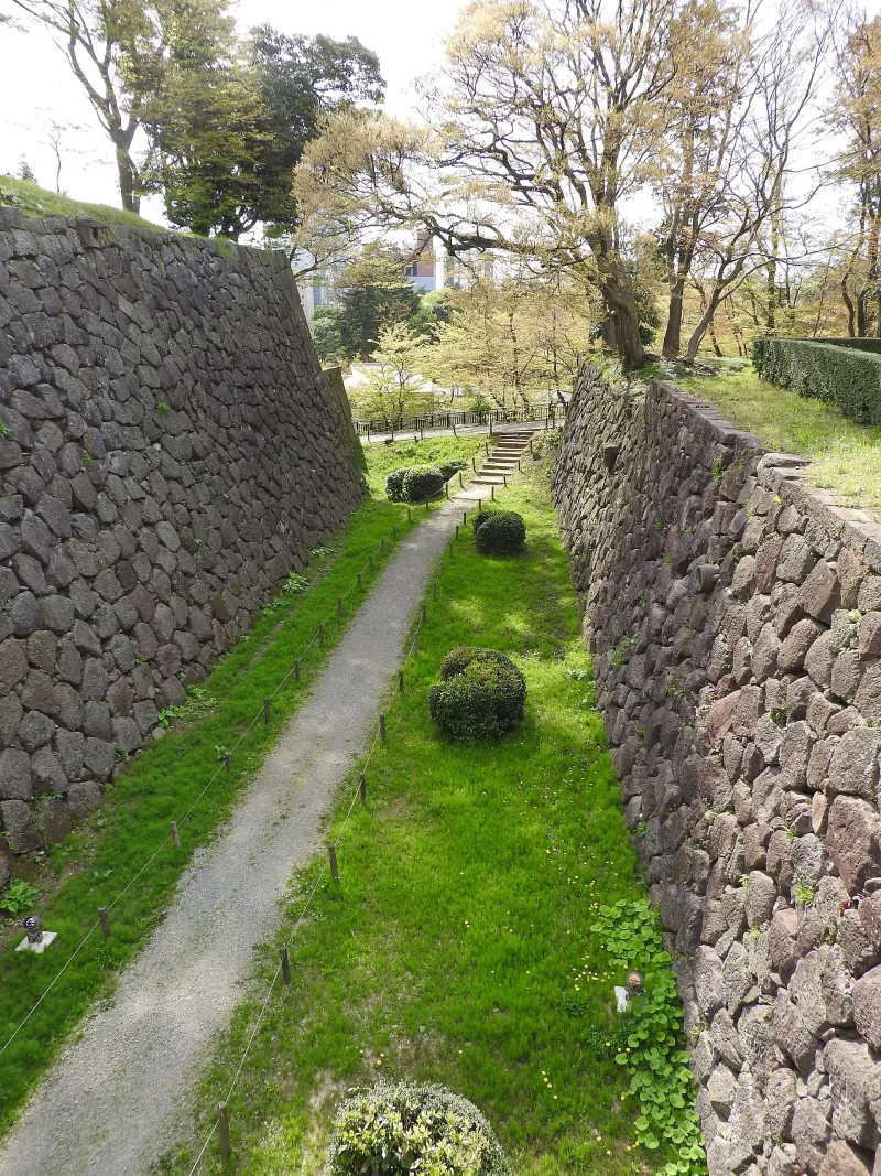 Path between old stone walls in Kanazawa Castle Park in early spring