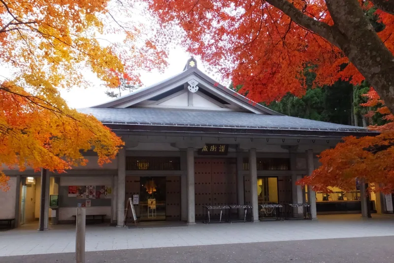 Sankozo treasure museum of Chuson-ji framed by red and orange autumn maple leaves