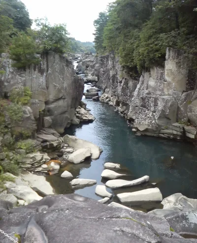 Grey rock walls and water-worn boulders along the river at Genbikei Gorge