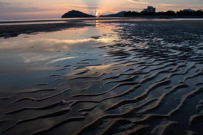 Rippled wet sand and tide pools reflecting the evening sky at Chichibugahama