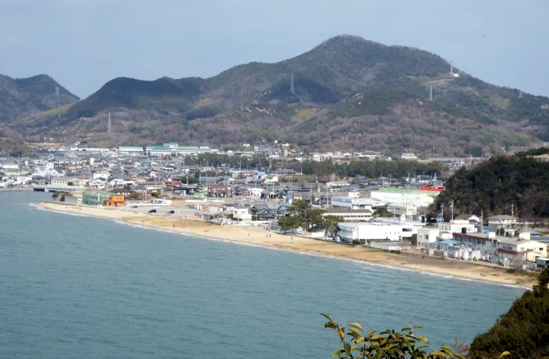 Overview of the long sandy Chichibugahama beach and the town of Nio with hills behind