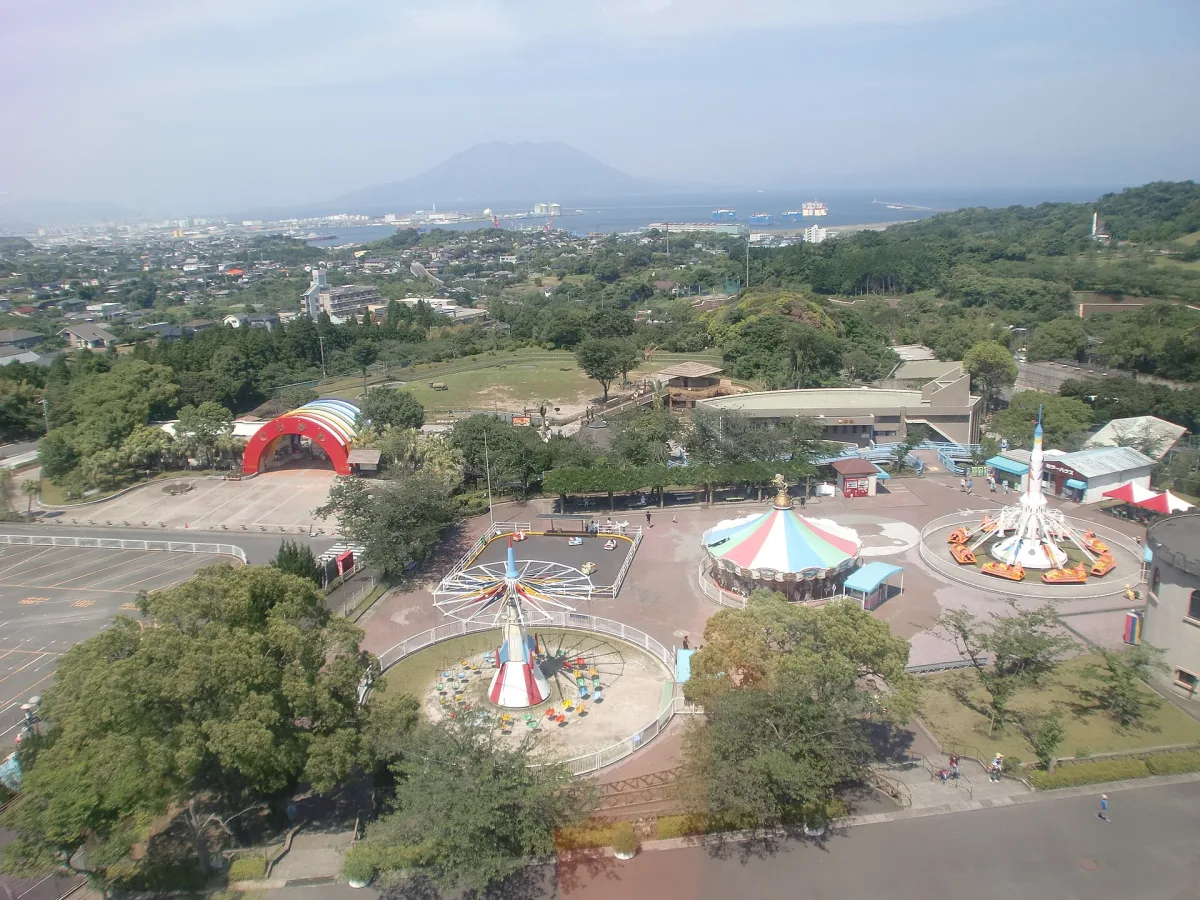 View over the zoo's small amusement park toward Kinko Bay and Sakurajima in the distance