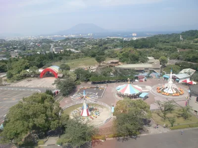 View over the zoo's small amusement park toward Kinko Bay and Sakurajima in the distance