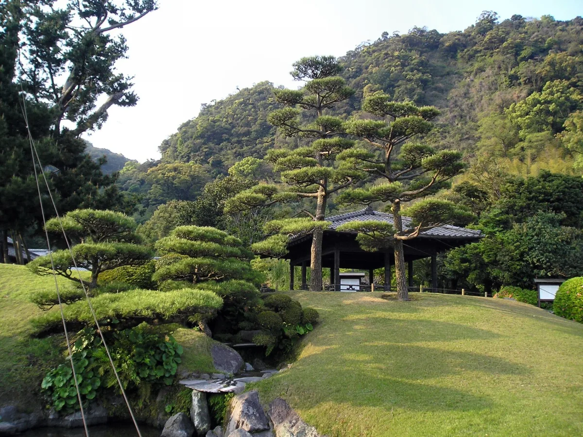 Lawn, pruned pine trees and a pavilion in the Sengan-en garden, Kagoshima