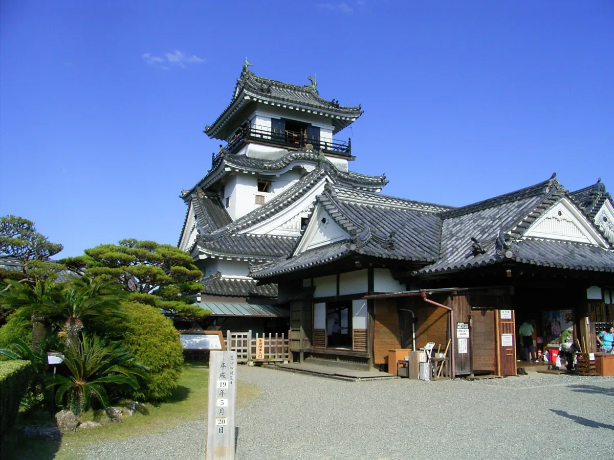 Kochi Castle's white keep rising behind the low wooden Honmaru Palace building