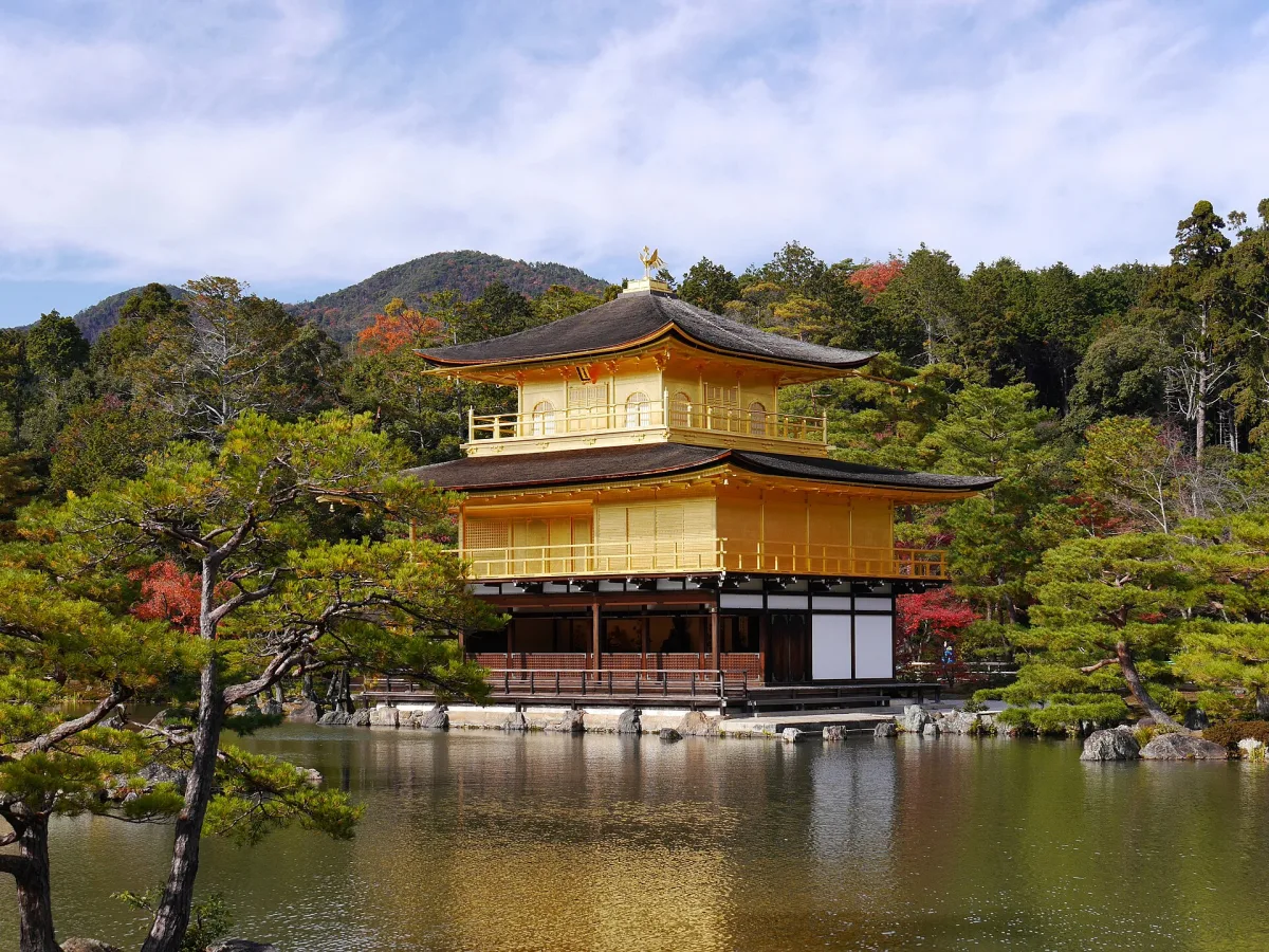 The gold-leaf Golden Pavilion of Kinkaku-ji reflected in Kyokochi Pond under a blue sky