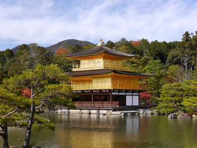 The gold-leaf Golden Pavilion of Kinkaku-ji reflected in Kyokochi Pond under a blue sky