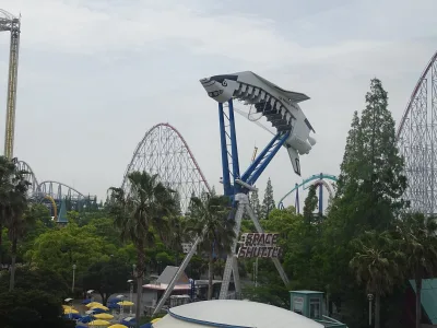 Shuttle-shaped ride in front of large roller coaster tracks at Nagashima Spa Land