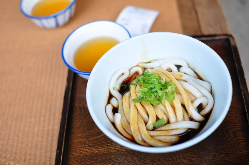 A bowl of thick Ise udon noodles in dark sauce served at a shop in Okage Yokocho