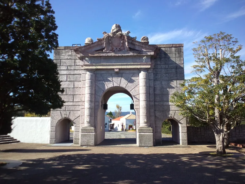 Stone Gate of Pomegranates replica under a blue sky at Parque España