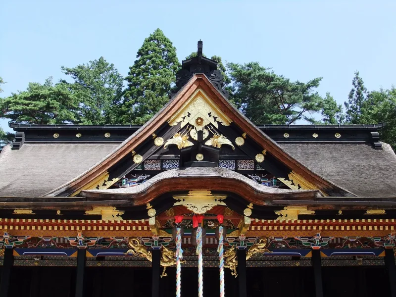 Close view of the ornate gable and carvings on Osaki Hachimangu's worship hall