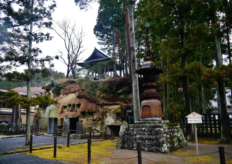 Temple grounds of Zuiganji with carved rock caves, a stone pagoda and tall trees