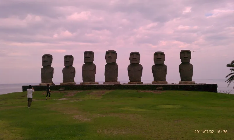 The seven moai of Sun Messe Nichinan on a grassy hilltop under a pink evening sky