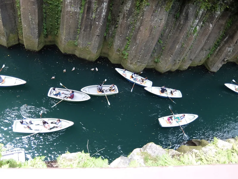 Rowing boats on the river below the columnar cliffs of Takachiho Gorge