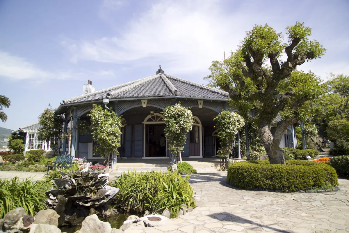The former Glover House, a low veranda house with tiled roof and garden