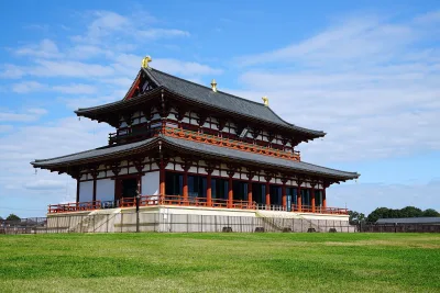 The reconstructed vermilion Former Imperial Audience Hall (Daigokuden) of Heijo Palace on a lawn under blue sky