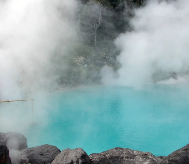 Steam rising from the turquoise water of Umi Jigoku hot spring in Beppu