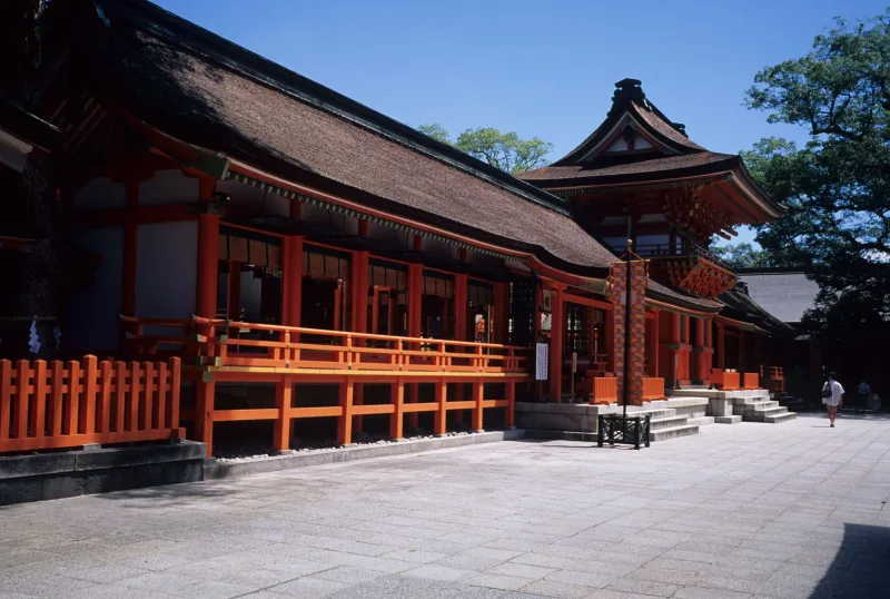 Long vermilion shrine buildings with dark bark roofs at Usa Jingu