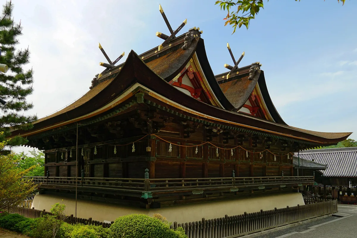 The National Treasure main hall of Kibitsu Shrine with its twin gabled roofs under a blue sky