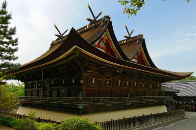 The National Treasure main hall of Kibitsu Shrine with its twin gabled roofs under a blue sky