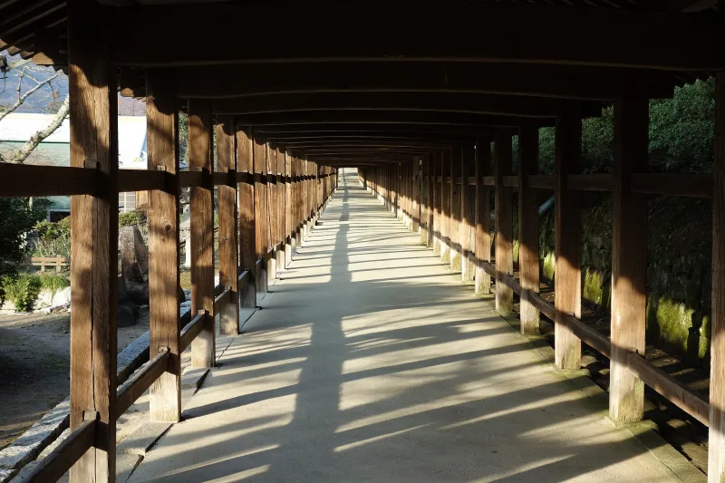 The long wooden covered corridor of Kibitsu Shrine stretching straight ahead